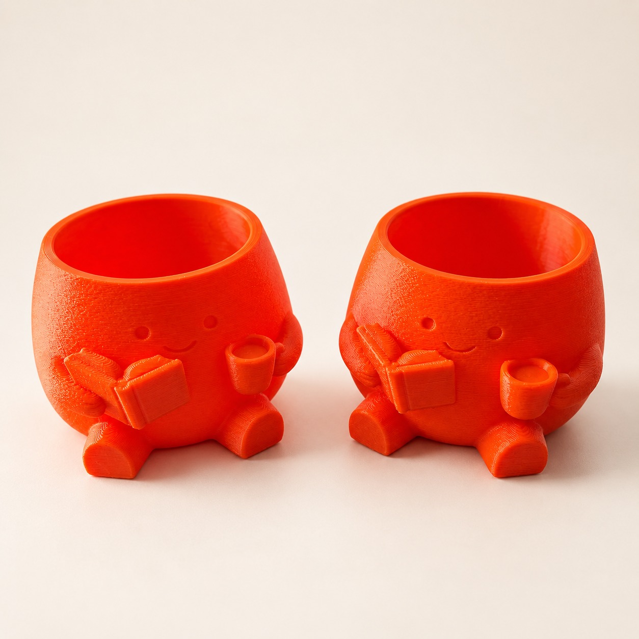 Cheerful orange planters holding a book and a little cup.